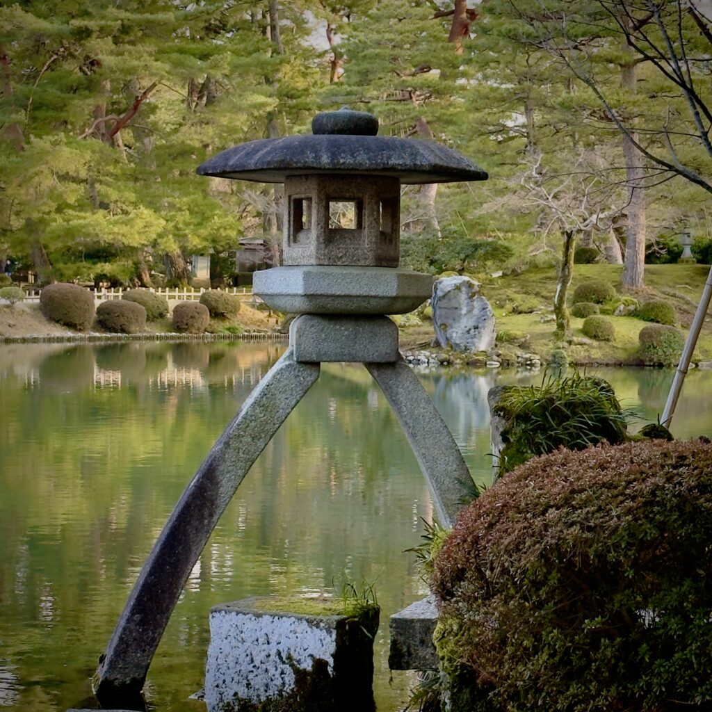 Kotoji toro stone lantern reflected in the pond at Kenroku-en garden, one of Japan's three great gardens, Kanazawa