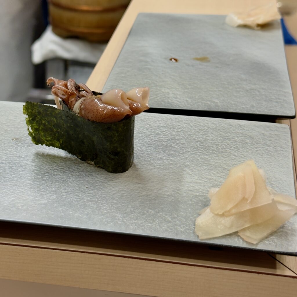 Nigiri being prepared at the wooden counter at Tachiguizushi Akira standing sushi bar in Shimbashi, Tokyo